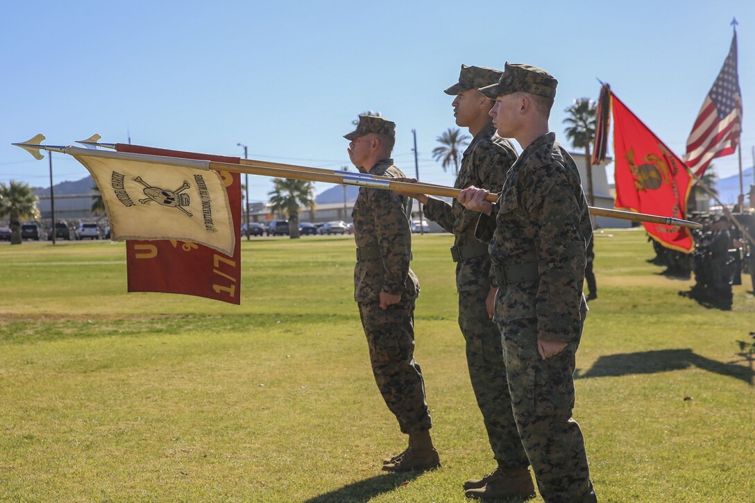A platoon from 1st Battalion, 7th Marine Division, gives a guidon salute during the post and relief ceremony for Sgt. Maj. Michael E. Cedeno, off going sergeant major, 1st Battalion, 7th Marine Regiment, Marine Corps Air Ground Combat Center Twentynine Palms, Calif., and Sgt. Maj. Brian E. Anderson, incoming sergeant major, 1/7, MCAGCC, at the commanding general’s lawn aboard Marine Corps Air Ground Combat Center Twentynine Palms, Calif., Jan. 11, 2018. During the ceremony Cedeno relinquished his post as sergeant major to Anderson. (Official Marine Corps photo by Lance Cpl. Margaret Gale)