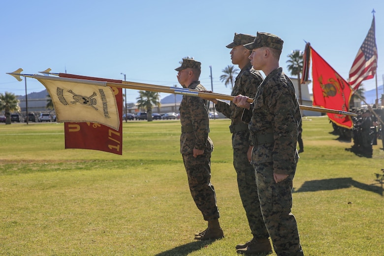 A platoon from 1st Battalion, 7th Marine Division, gives a guidon salute during the post and relief ceremony for Sgt. Maj. Michael E. Cedeno, off going sergeant major, 1st Battalion, 7th Marine Regiment, Marine Corps Air Ground Combat Center Twentynine Palms, Calif., and Sgt. Maj. Brian E. Anderson, incoming sergeant major, 1/7, MCAGCC, at the commanding general’s lawn aboard Marine Corps Air Ground Combat Center Twentynine Palms, Calif., Jan. 11, 2018. During the ceremony Cedeno relinquished his post as sergeant major to Anderson. (Official Marine Corps photo by Lance Cpl. Margaret Gale)