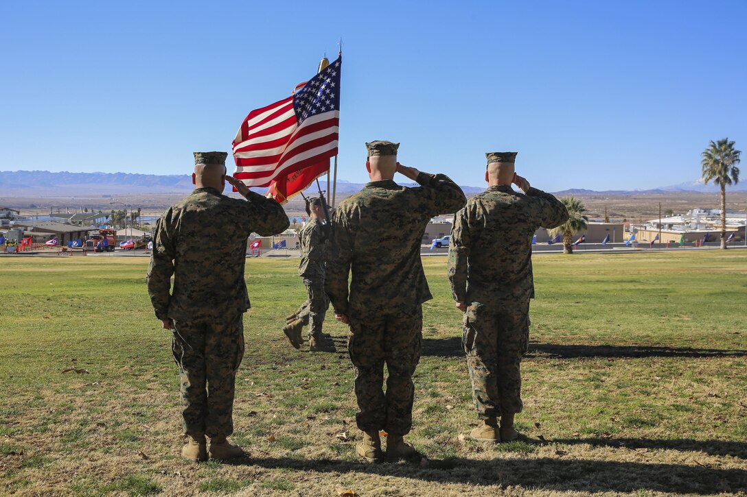 Sgt. Maj. Michael E. Cedeno, off going sergeant major, 1st Battalion, 7th Marine Regiment, Marine Corps Air Ground Combat Center Twentynine Palms, Calif., Sgt. Maj. Brian E. Anderson, incoming sergeant major, 1/7, MCAGGC, and Lt. Col. Erick T. Clark, commanding officer, 1/7, MCAGCC, salute the colors during the pass and review during the post and relief ceremony at the commanding generals lawn aboard the Combat Center, Jan. 11, 2018. During the ceremony Cedeno relinquished his post as sergeant major to Anderson. (Official Marine Corps photo by Lance Cpl. Margaret Gale)