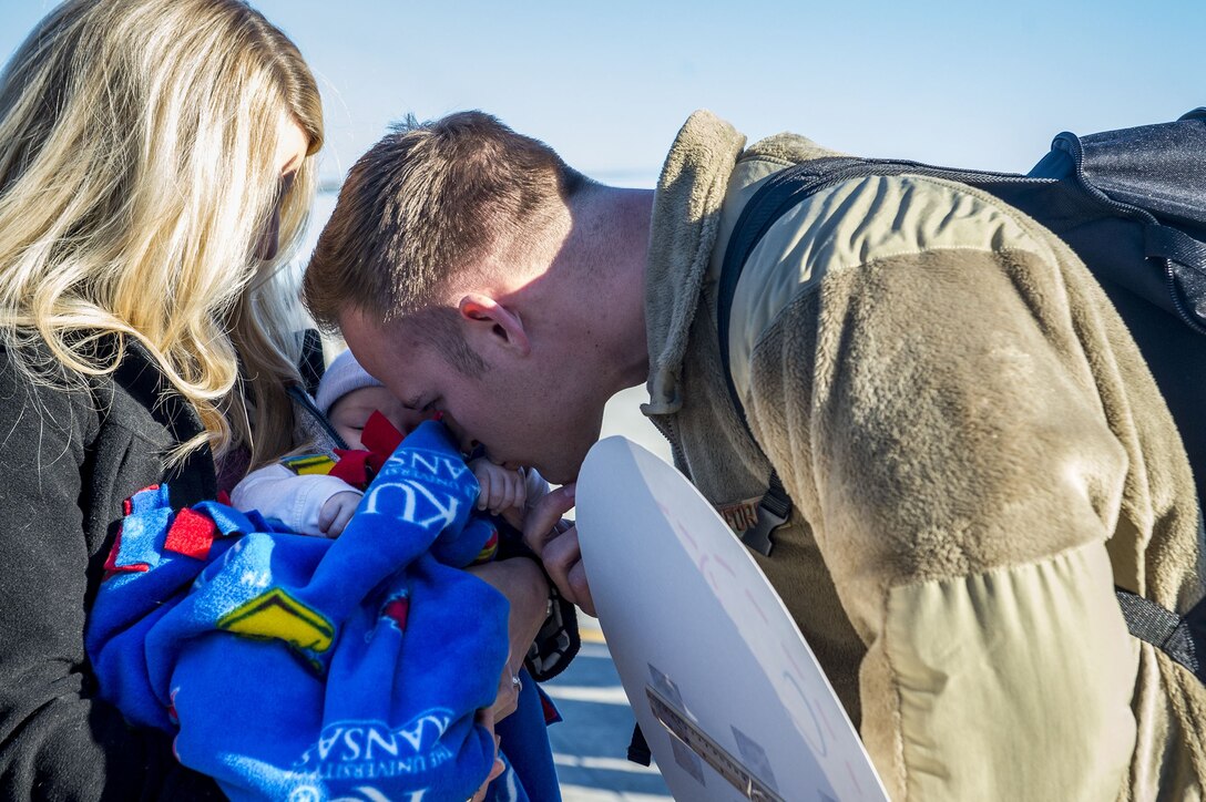 Capt. Brett Gudim, 74th Fighter Squadron, greets his wife Katy and kisses his son, Luke’s hand during a redeployment ceremony, Jan. 19, 2018, at Moody Air Force Base, Ga. Luke was born while Gudim was deployed for seven months in support of Operation Inherent Resolve to defeat ISIS in designated areas in Iraq and Syria.