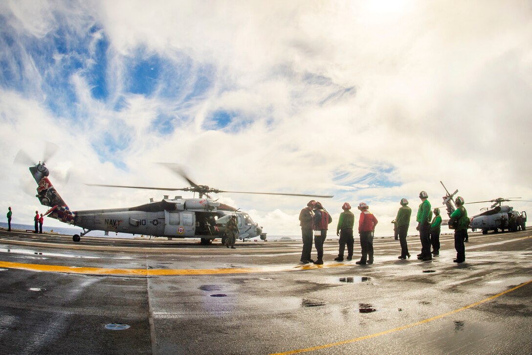 An MH-60S Sea Hawk helicopter prepares to take off from the flight deck.