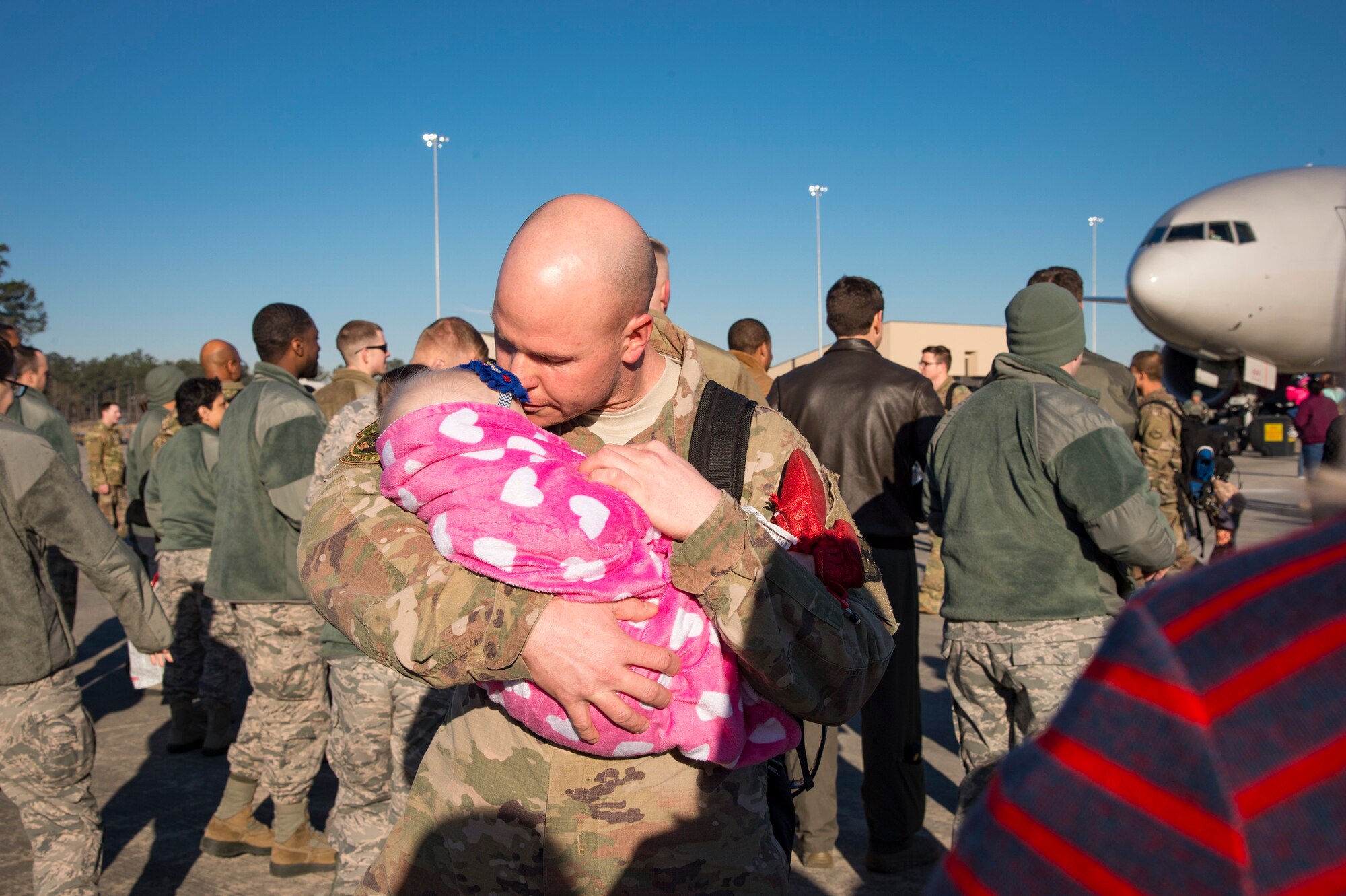 Tech. Sgt. Travis Van Haren, 74th Aircraft Maintenance Unit weapons expediter, kisses his baby during a redeployment ceremony, Jan. 19, 2018, at Moody Air Force Base, Ga. The 74th Fighter Squadron conducted around-the-clock planning and operations, which have decimated ISIS’ fighting capacity with precise strikes, erasing tens of thousands of fighters from ISIS rosters. (U.S. Air Force photo by Andrea Jenkins)