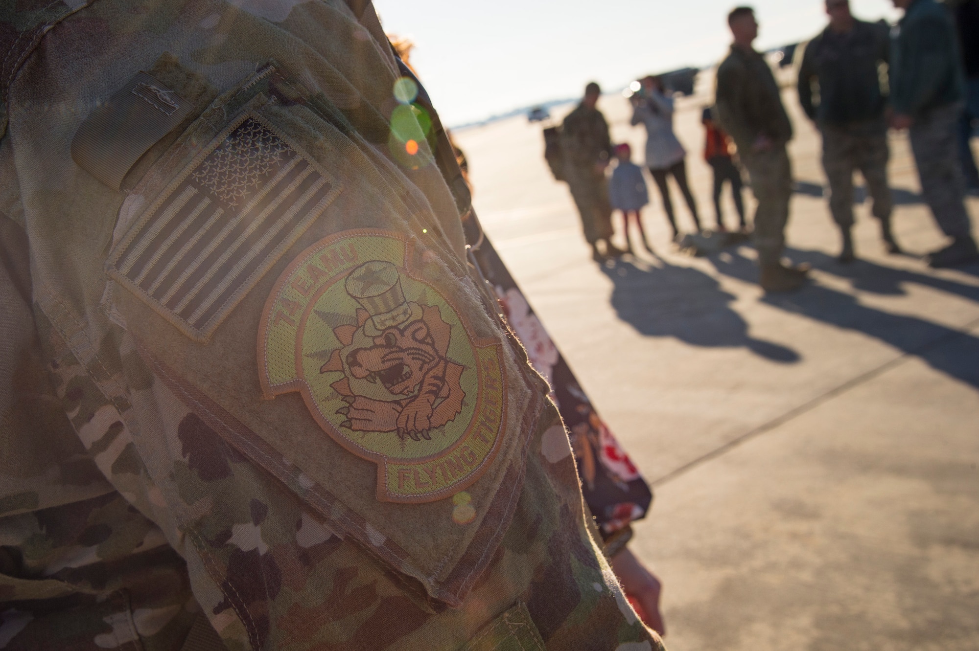 A 74th Expeditionary Aircraft Maintenance Unit patch rests on the arm of a returning maintainer during a redeployment ceremony for the 74th Fighter Squadron, Jan. 19, 2018, at Moody Air Force Base, Ga. The 74th FS conducted around-the-clock planning and operations, which have decimated ISIS’ fighting capacity with precise strikes, erasing tens of thousands of fighters from ISIS rosters. (U.S. Air Force photo by Andrea Jenkins)