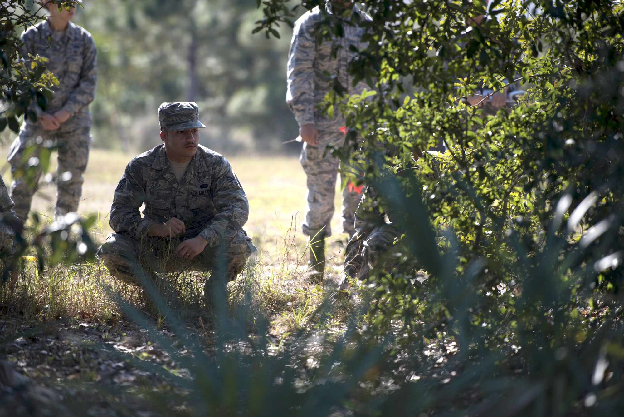 U.S. Air Force Senior Airman Brenden Nicol, a fitness specialist assigned to the 6th Force Support Squadron, bends down to search his area for any personal belongings or remains during a search and recovery training exercise Jan. 17, 2018, at MacDill Air Force Base, Fla.
