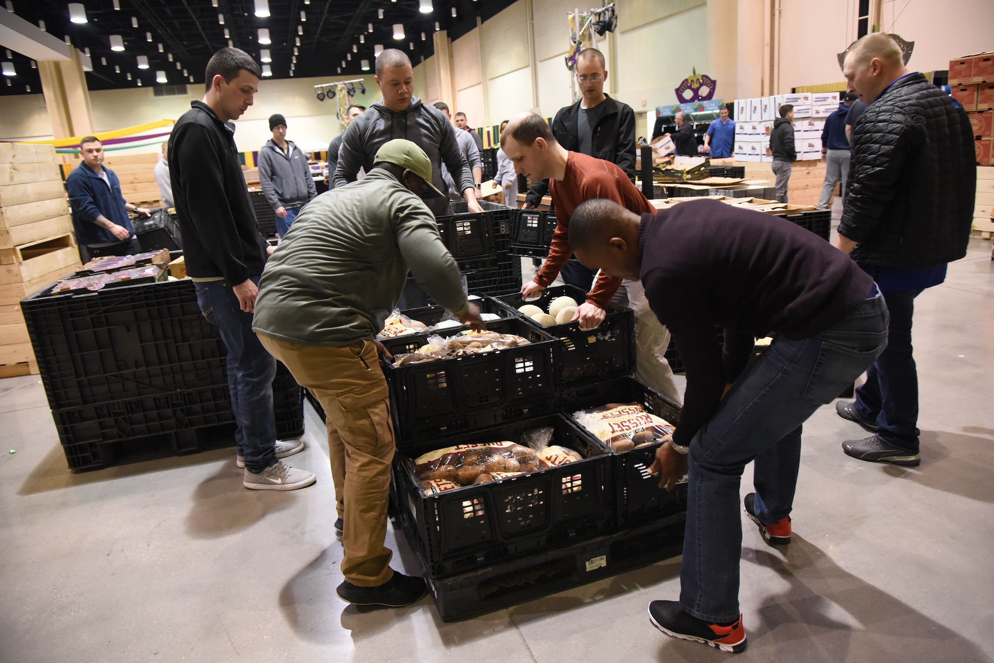 Keesler personnel package food items into crates during a food drive at the Mississippi Coast Coliseum and Convention Center Jan. 16, 2018, Biloxi, Mississippi. More than 80 Airmen participated in the wing-level community sponsored volunteer event packaging over 21,000 pounds of food, equating to approximately 17,500 meals that will be provided to hunger relief. (U.S. Air Force photo by Kemberly Groue)