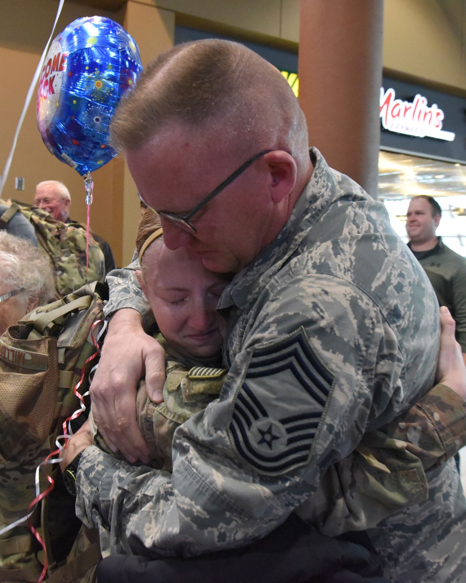 Chief Master Sgt. Jeff Miller hugs his daughter Tech. Sgt. Elizabeth Miller, of the 119th Security Forces Squadron, North Dakota Air National Guard, as she returns from deployment.