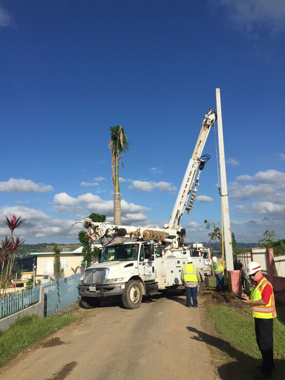 Daniel Heath, a realty specialist from the U.S. Army Corps of Engineers, Walla Walla District, (right) provides contract-performance quality assurance as contractors erect new concrete-reinforced 50-feet-tall power poles Nov. 30, 2017, near Puerto Rico’s Aguadilla area. Heath deployed from Walla Walla, Washington, Nov. 14 to Dec. 28, 2017, to help support FEMA’s Power Grid Restoration mission in Puerto Rico.