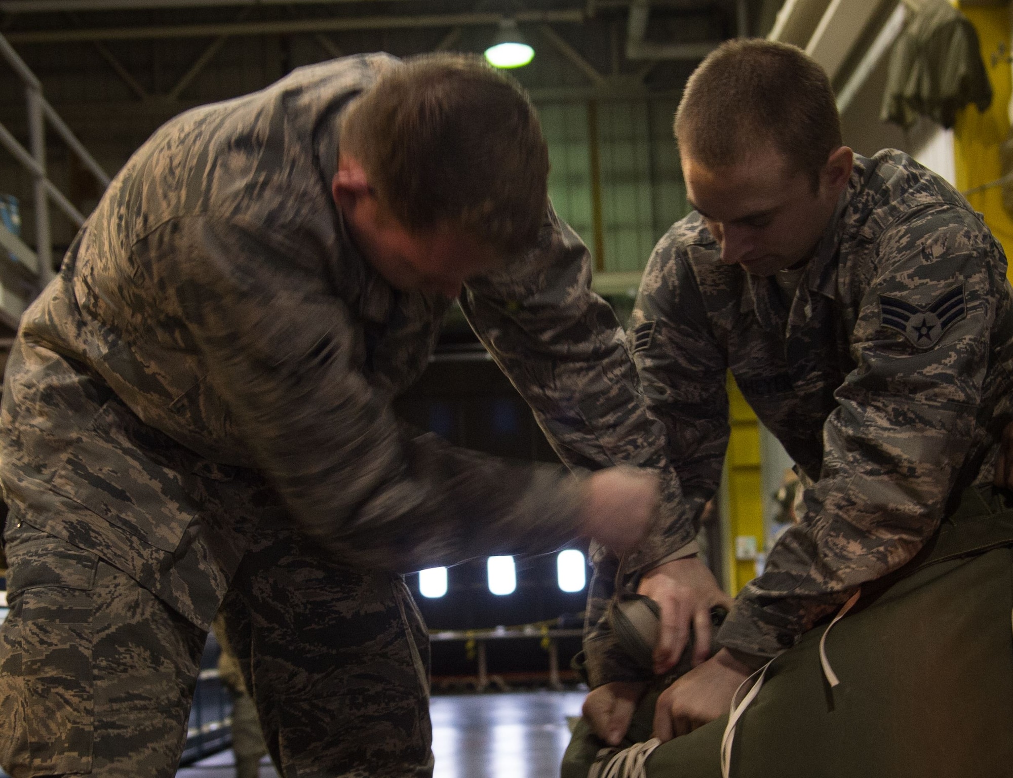 U.S. Air Force Airman 1st Class Zachary Barber (left) and Senior Airman Sean Obermeyer, 773d Logistics Readiness Squadron combat mobility technicians, pack a G-12 cargo parachute at Joint Base Elmendorf-Richardson, Alaska, Jan. 18, 2018. C-130 Hercules and C-17 Globemaster III aircraft use G-12 cargo parachutes to support heavy cargo pallets weighing between 501 and 2,200 pounds, providing critical supplies to warfighters down range as well as rescue missions in Alaska.
