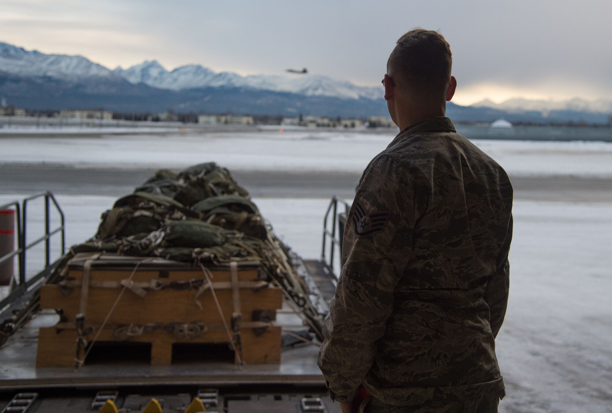 U.S. Air Force Staff Sgt. Douglas Moye, 773d Logistics Readiness Squadron combat mobility supervisor, oversees the departure of cargo pallets on a Halvorsen Loader at Joint Base Elmendorf-Richardson, Alaska, Jan. 18, 2018. The Halvorsen Loader is a rapidly deployable, high-reach mechanized aircraft loader that can transport and lift up to 25,000 pounds of cargo and load it onto military and civilian aircraft. JBER’s combat mobility flight is the largest in PACAF, providing C-130 Hercules and C-17 Globemaster III unilateral airdrop and airland training for two wings and three squadrons while at home station, as well as all of the airdrop training to Red Flag Alaska.