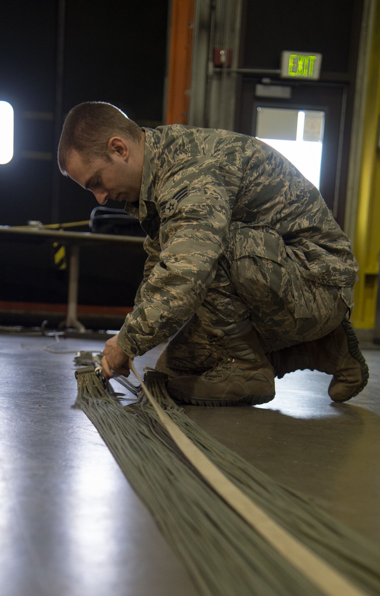 U.S. Air Force Senior Airman Sean Obermeyer, 773d Logistics Readiness Squadron combat mobility technicians, prepares a G-12 cargo parachute for packing at Joint Base Elmendorf-Richardson, Alaska, Jan. 18, 2018. C-130 Hercules and C-17 Globemaster III aircraft use G-12 cargo parachutes to support heavy-cargo pallets weighing between 501 and 2,200 pounds, providing critical supplies to warfighters down range as well as rescue missions in Alaska.