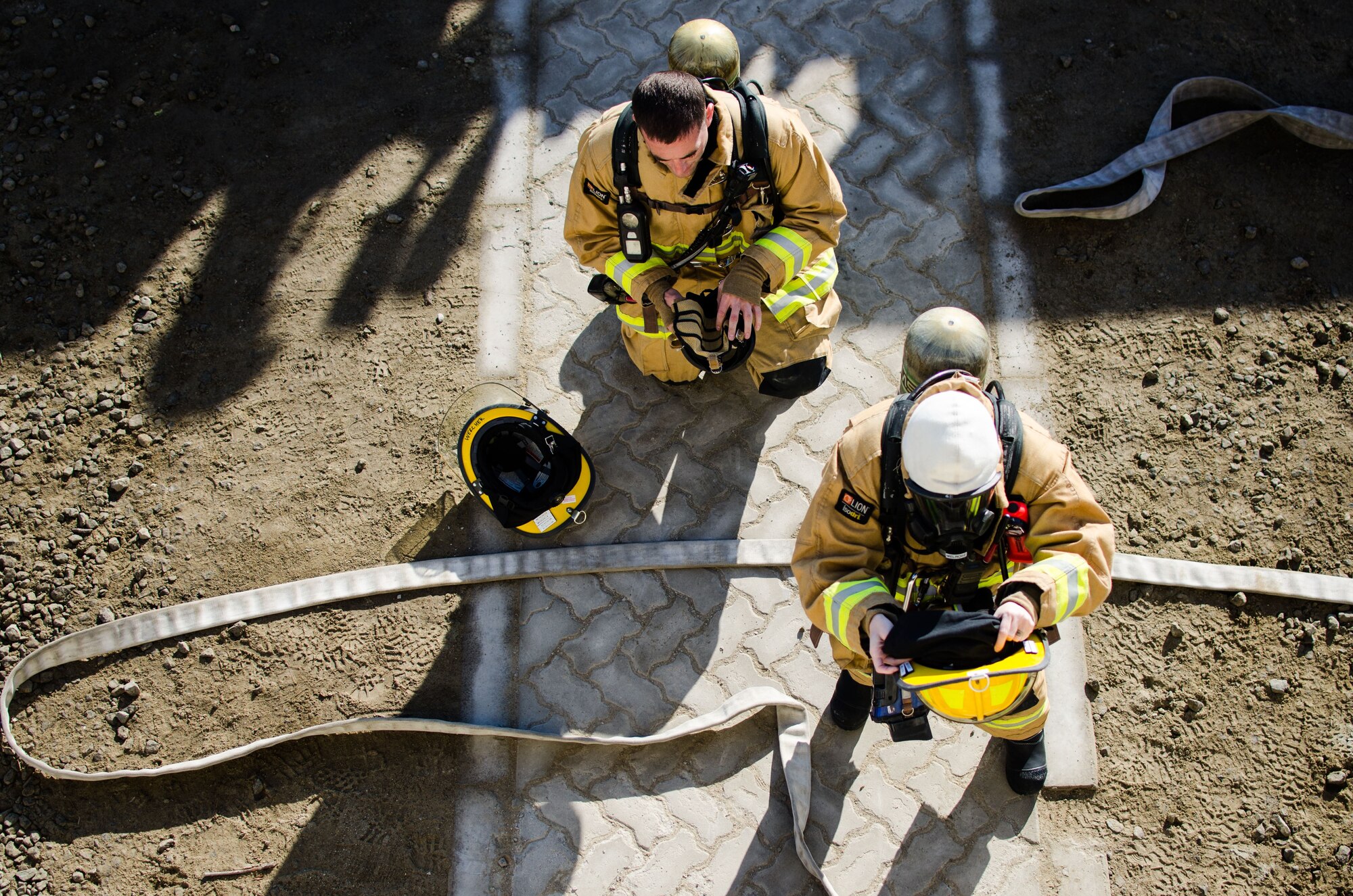 U.S Air Force Senior Airman Carolyn Melrose and Senior Airman Steven Werchek, 380th Expeditionary Civil Engineer Squadron firefighters, prepare to enter a simulated burning building at Al Dhafra Air Base, United Arab Emirates, Jan. 12, 2018. Senior Airman Melrose was the lead firefighter on scene which accomplished one task in route to completing her Fire Officer One certificate. (U.S. Air National Guard photo by Staff Sgt. Colton Elliott)