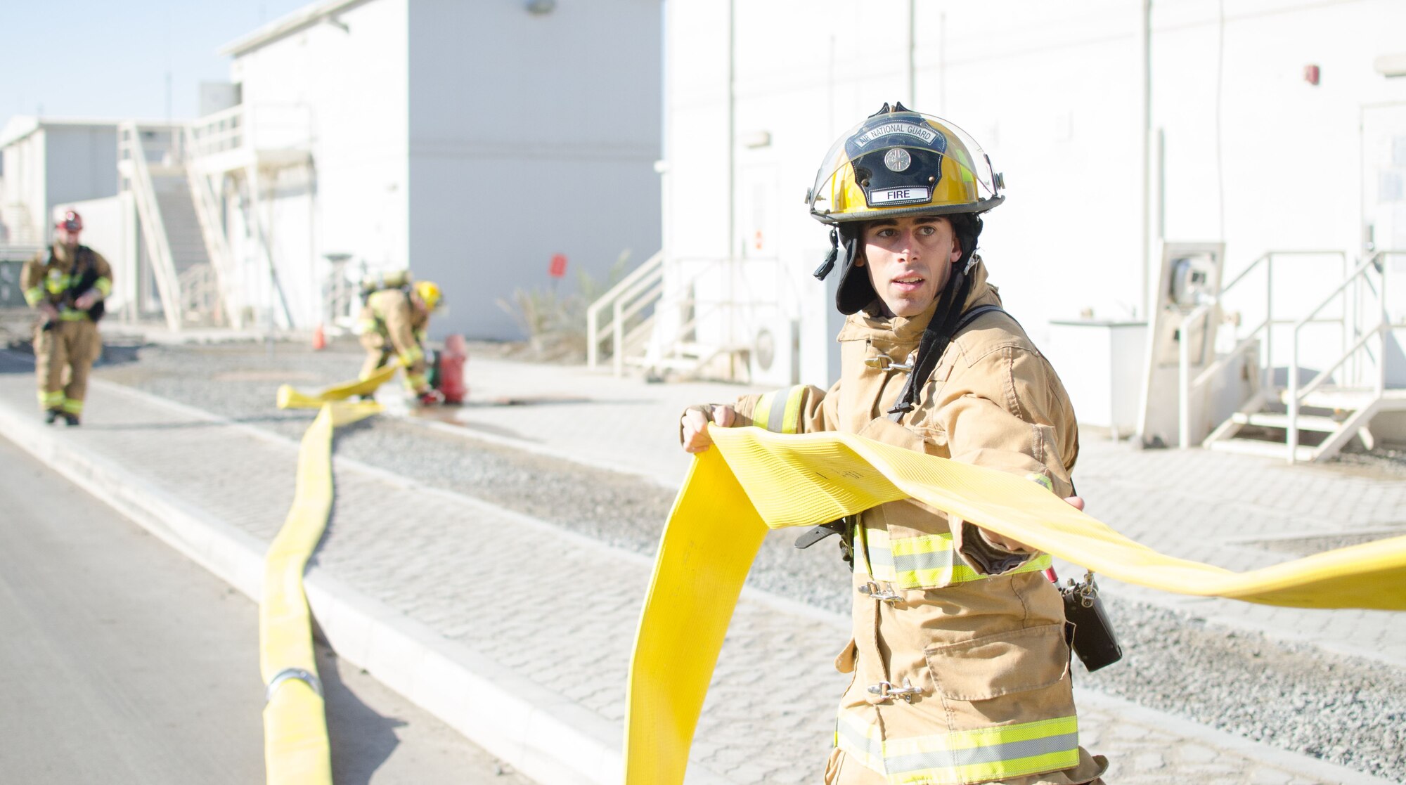 U.S. Air Force Airman 1st Class Jacob Bull, 380th Expeditionary Civil Engineer Squadron firefighter removes a water supply line from a fire truck during a training exercise at Al Dhafra Air Base, United Arab Emirates, Jan. 12, 2018. The training evaluated firefighters on extinguishing a fire and rescuing a victim while applying firefighting procedures (U.S. Air National Guard photo by Staff Sgt. Colton Elliott)