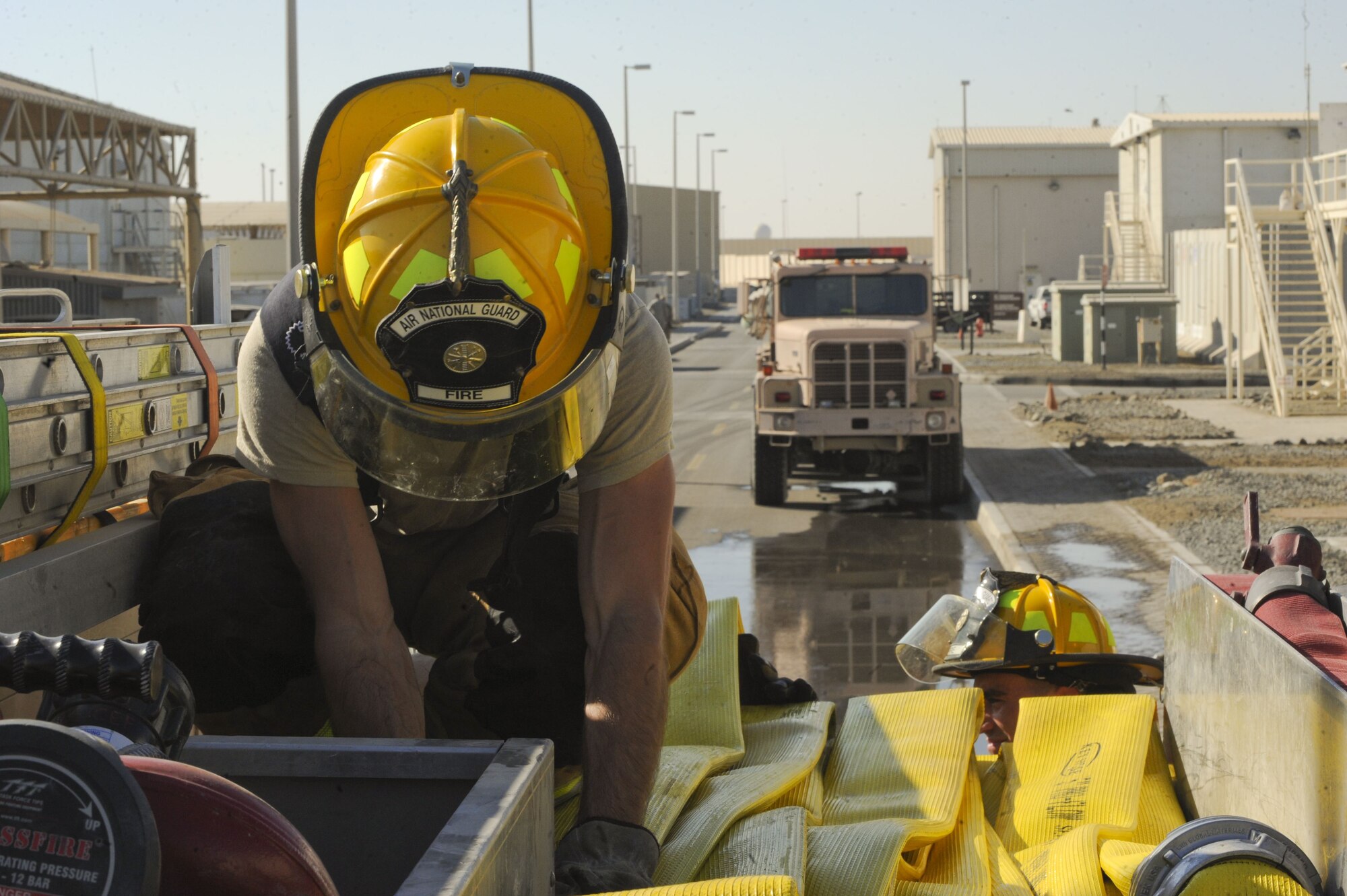 U.S. Air Force Airman 1st Class Jacob Bull, 380th Expeditionary Civil Engineer Squadron firefighter, stores a hose after a simulated building fire at Al Dhafra Air Base, United Arab Emirates, Jan. 12, 2018. During the simulation, firefighters used the “two-in, two-out” policy mandating firefighters never enter a building alone. (U.S. Air Force photo by Airman 1st Class D. Blake Browning)