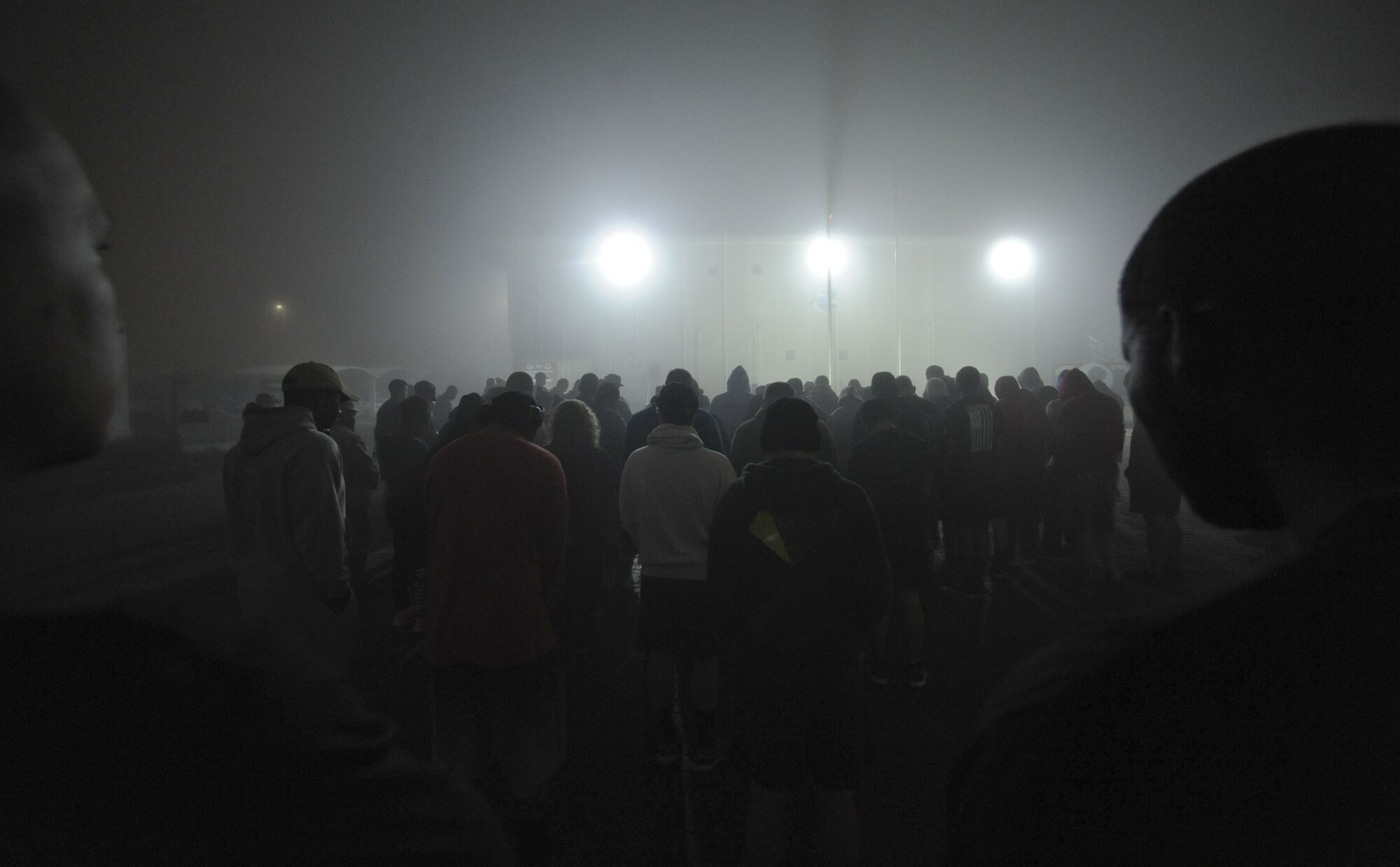 Service members deployed to the 380th Air Expeditionary Wing, Al Dhafra Air Base, United Arab Emirates, stand in silence during the invocation at the Dr. Martin Luther King Jr. observance day memorial walk Jan. 15, 2018. A dense fog prefaced the event and lingered as the many acts and accomplishments of Dr. King’s life were read. (U. S. Air Force photo by Airman 1st Class D. Blake Browning)