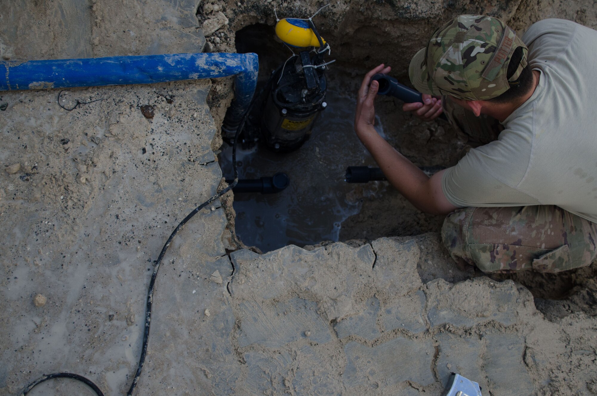 Staff Sgt. Joshua Potter, 380th Expeditionary Civil Engineering Squadron, water and fuels system specialist, repairs a cracked water line at Al Dhafra Air Base, United Arab Emirates Jan. 11, 2018.  A Pipeline can burst through a variety of ways: pressure change in the atmosphere, earthquakes and low or high temperatures. (U.S. Air National Guard by Staff Sgt. Colton Elliott)