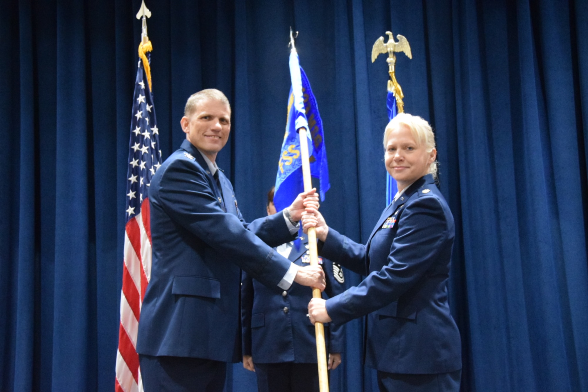 Maj. Robin L. Ecks takes the 433rd Force Support Squadron guidon from Col. David Enfield, 433rd Mission Support Group commander during an assumption of command ceremony held here Jan. 20, 2018.  She began her career as an enlisted member in 1996 and completed technical training as a health services management apprentice. (U.S. Air Force photo by Tech Sgt. Carlos J. Treviño)