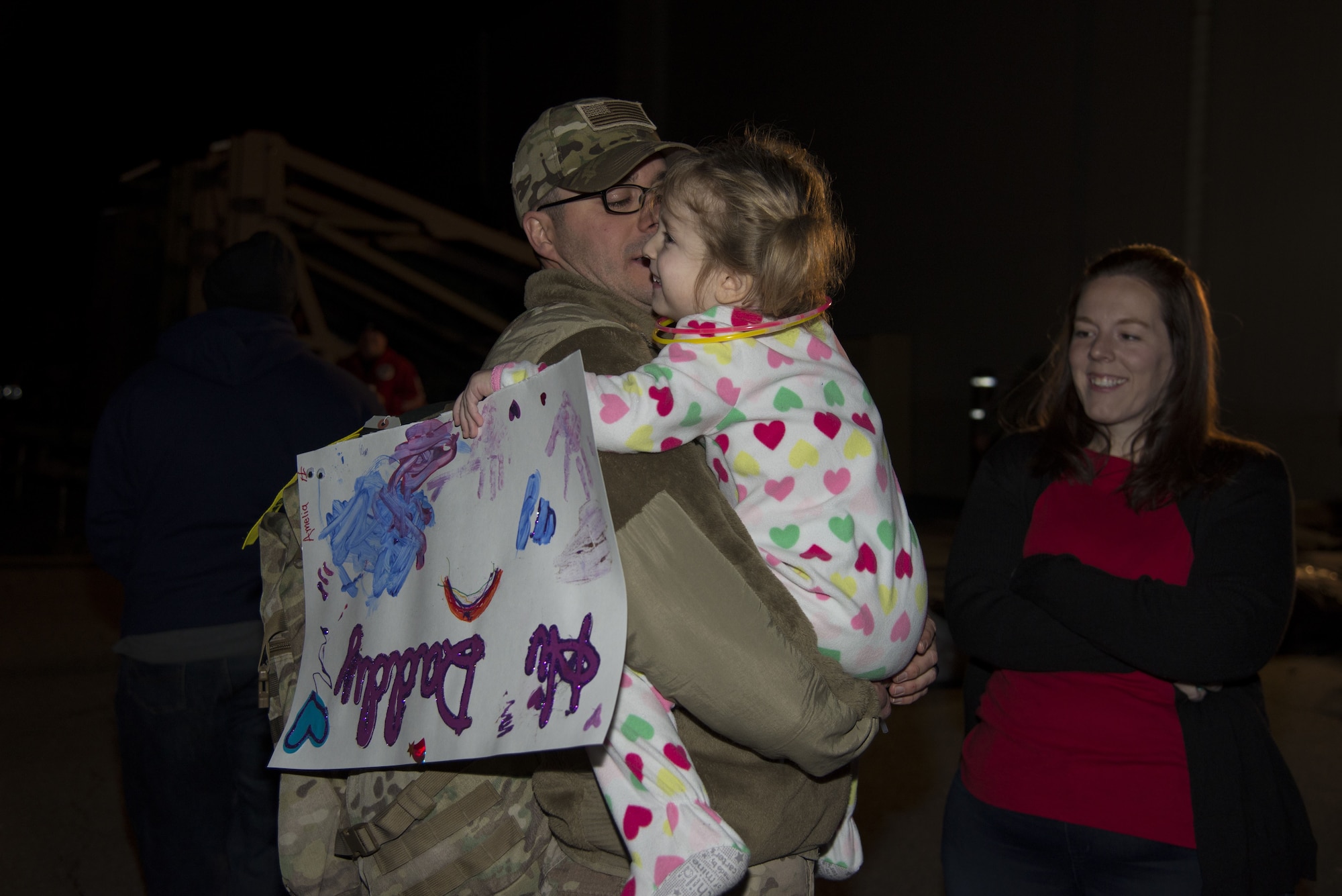 Master Sgt. Michael Johnson, 436th Security Forces Squadron defender, hugs his daughter, Amelia, as his wife, Kelly, looks on Jan. 21, 2018, at Dover Air Force Base, Del. The Johnson family was reunited after a six-month deployment to the Middle East. (U.S. Air Force Photo by Staff Sgt. Aaron J. Jenne)