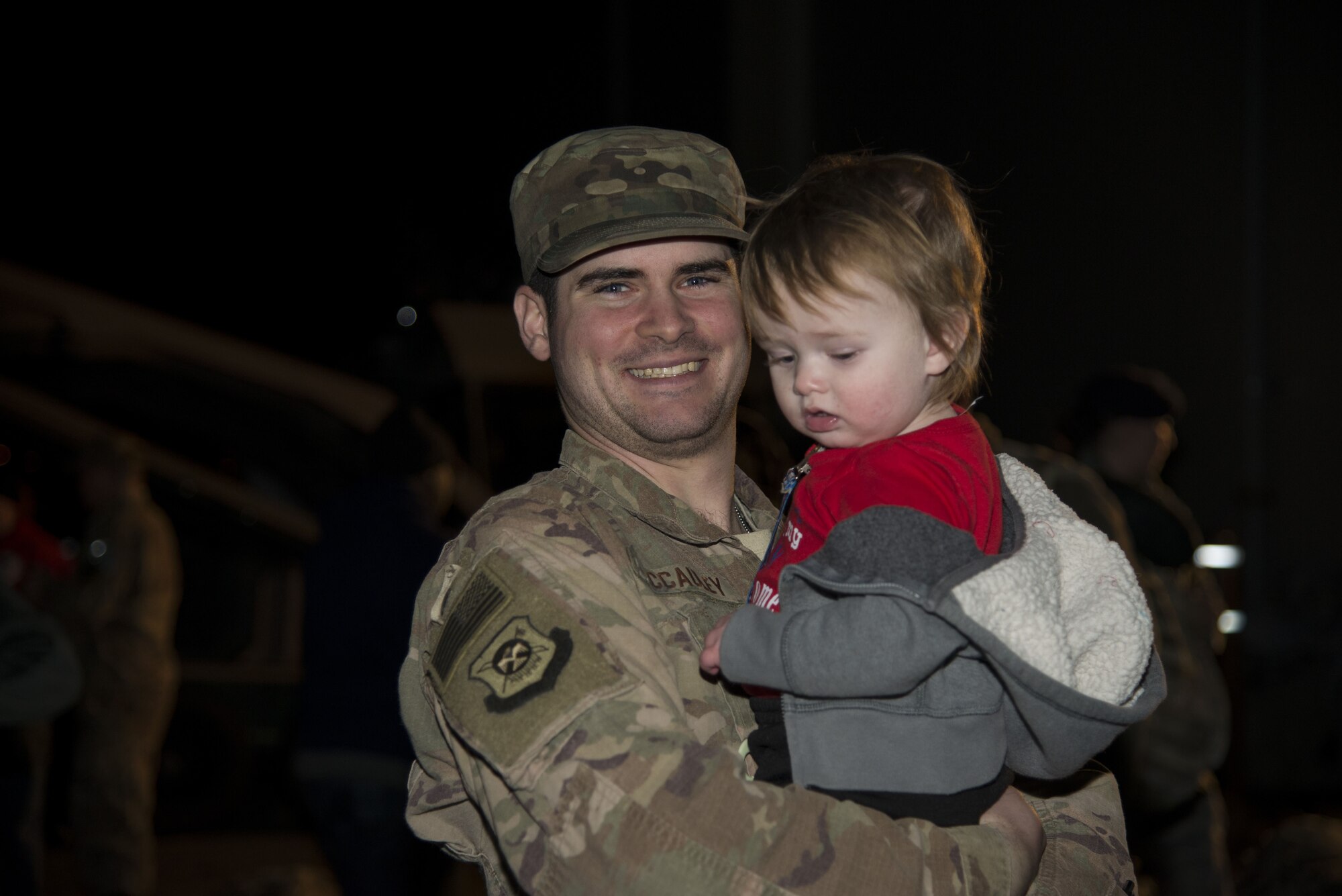 Staff Sgt. Issac McCauley, 436th Security Forces Squadron defender, holds Jaxon, his son, after returning home from deployment Jan. 21, 2018, at Dover Air Force Base, Del. McCauley is one of twelve defenders sent to the Middle East for a six-month deployment. (U.S. Air Force Photo by Staff Sgt. Aaron J. Jenne)