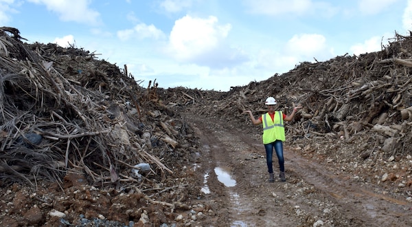 U.S. Army Corps of Engineers Debris Mission Manager Jasmine Smith stands among the mountain of vegetative debris that has been collected at one of 33 sites across Puerto Rico in support of Hurricane Maria recovery efforts.