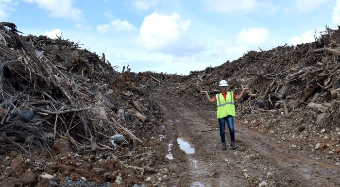 U.S. Army Corps of Engineers Debris Mission Manager Jasmine Smith stands among the mountain of vegetative debris that has been collected at one of 33 sites across Puerto Rico in support of Hurricane Maria recovery efforts.