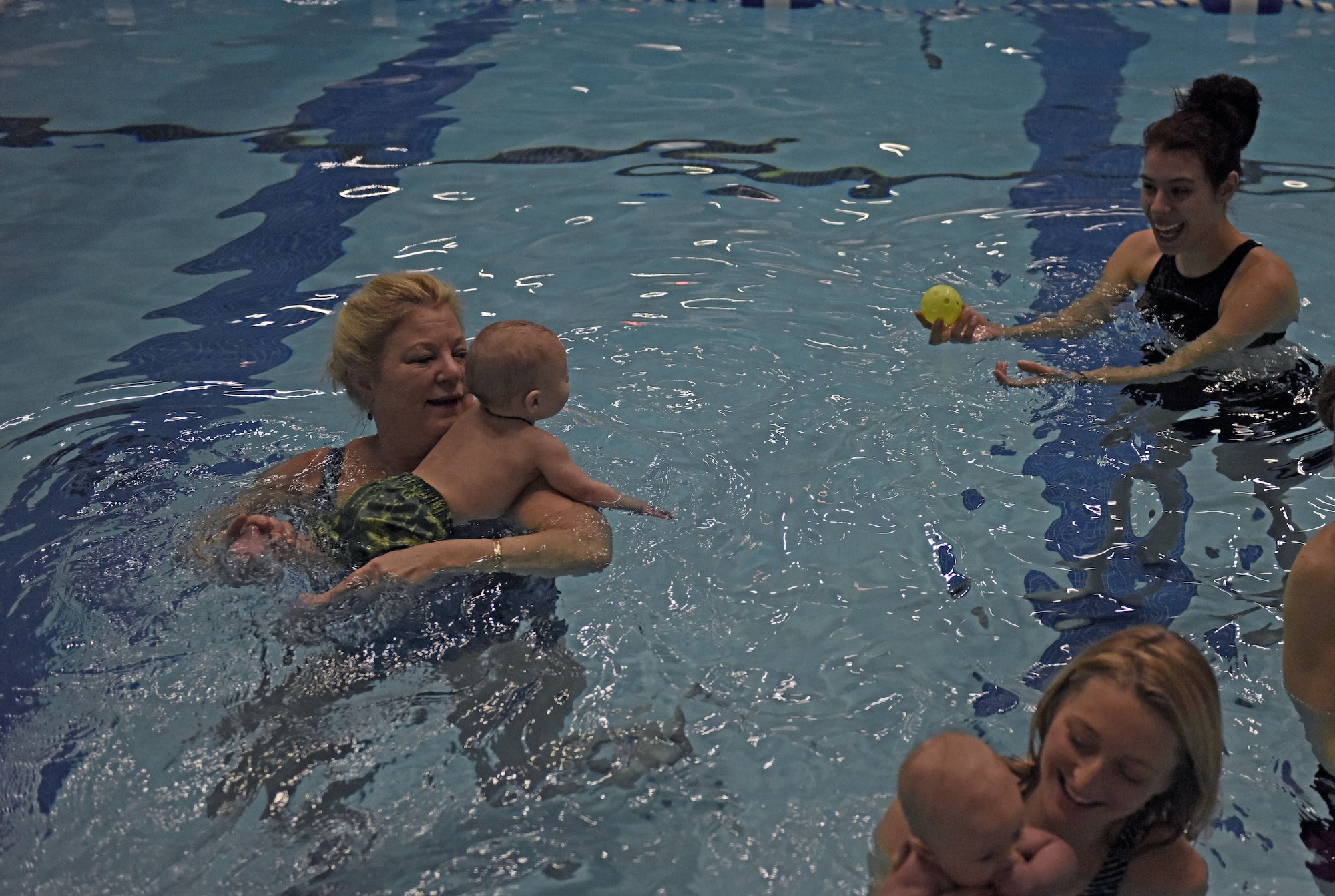 Mary Puffet Cook, 92nd Medical Group Family Advocacy Office nurse, works with a new parent on their baby’s motor skills during a water babies class at the Fitness Center at Fairchild Air Force Base, Washington, Jan. 16, 2018. Newborns learn through a parent’s eye contact, movements and music during the class. (U.S. Air Force photo/Airman 1st Class Jesenia Landaverde)