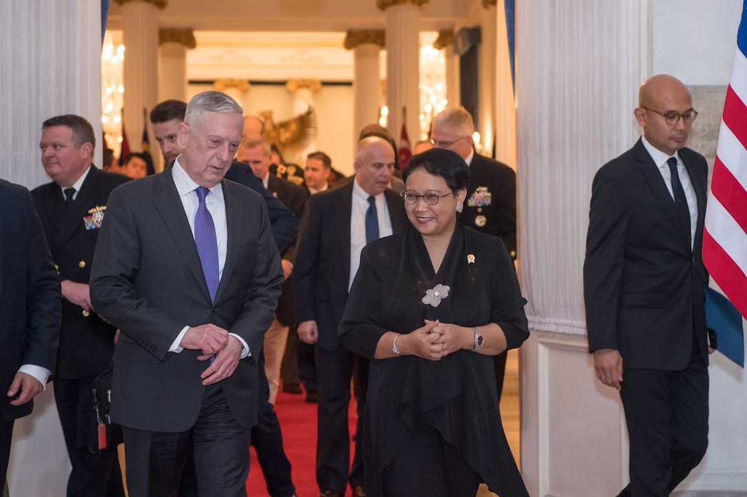 Defense Secretary James N. Mattis walks with Indonesia's foreign minister, followed by a group of people.