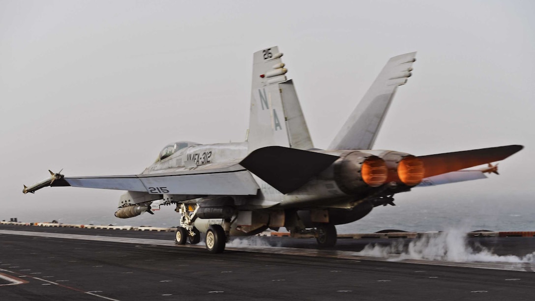An F/A-18C Hornet launches from the flight deck of an aircraft carrier