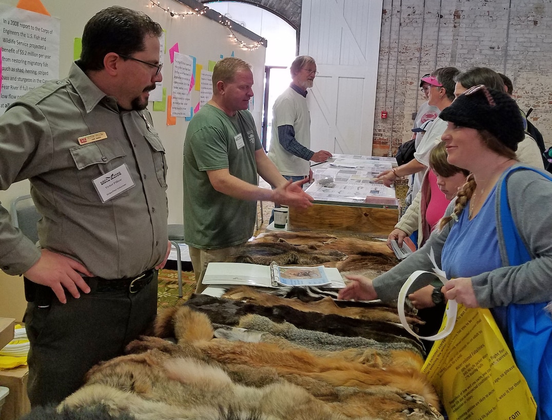 Ranger Victor Pillow, left, and Regulatory Project Manager Tom Charles, to his left, explain to visitors at their display the various plants, animals and fish that can be found at the Wilmington District’s Locks and Dams on the Cape Fear River during the annual Striper Fest Community Education Day held in Wilmington on Jan. 13th.