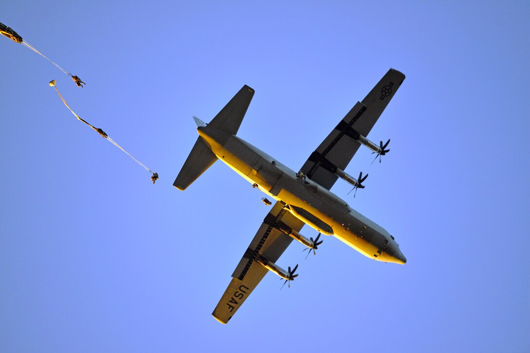 Soldiers exit an Air Force C-130 Hercules aircraft during an airborne operation.