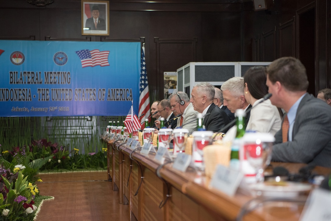 Defense Secretary James N. Mattis sits at a table with a group of U.S. defense officials.