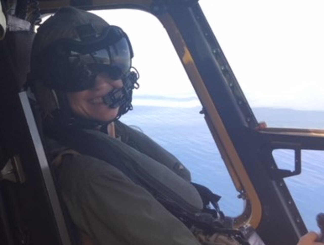 A Marine Corps helicopter pilot smiles while flying a CH-53E Super Stallion