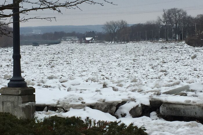 Snow and ice cover a river.