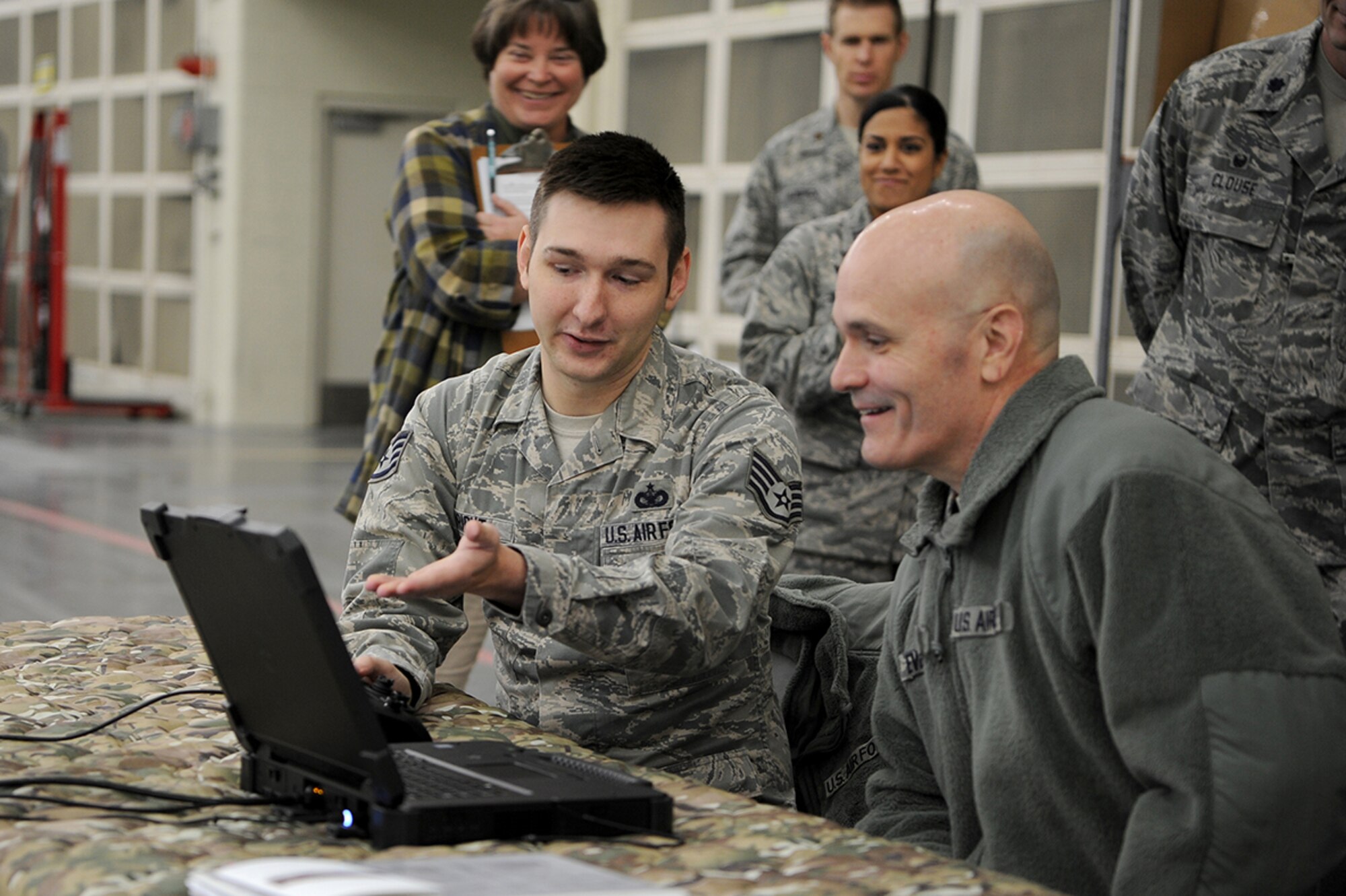 U.S. Air Force Staff Sgt. Evan Wright, left, 628th Security Forces Squadron, instructor, discusses the capabilities of the Man-Portable Anti-drone System Kit computer interface with U.S. Air Force General Carlton D. Everhart, Air Mobility Command commander, Jan. 17, 2018. Everhart visited Mobility Airmen from various units at Joint Base Charleston to gain valuable insight of their mission successes along with the challenges they may face while executing rapid global mobility.
