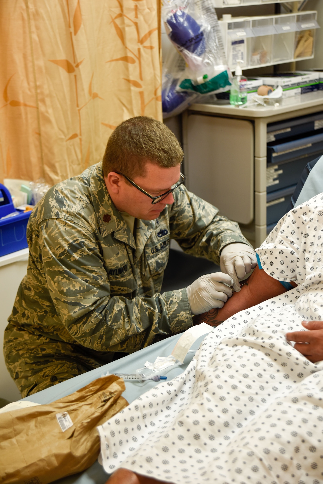 Maj. Justin Aylward, 114th Medical Group clinical nurse, inserts an IV on a patient at the Tripler Army Medical Center emergency room Jan. 17, 2018, Honolulu, HI.