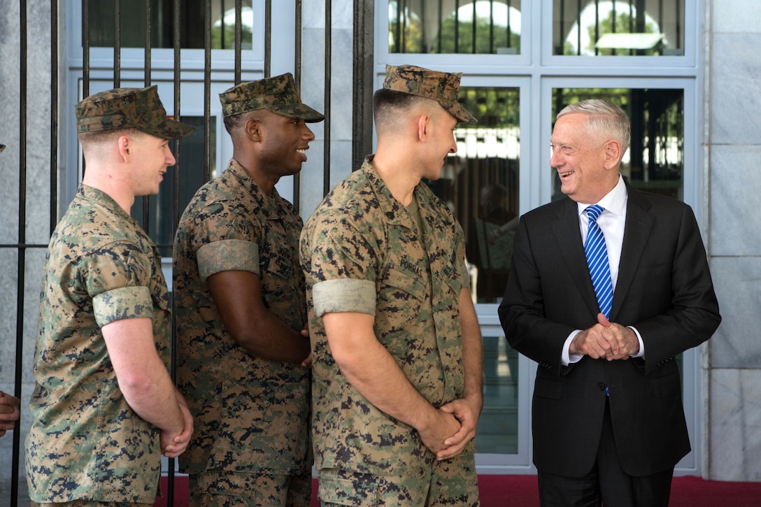 Defense Secretary James N. Mattis speaks with three Marines.