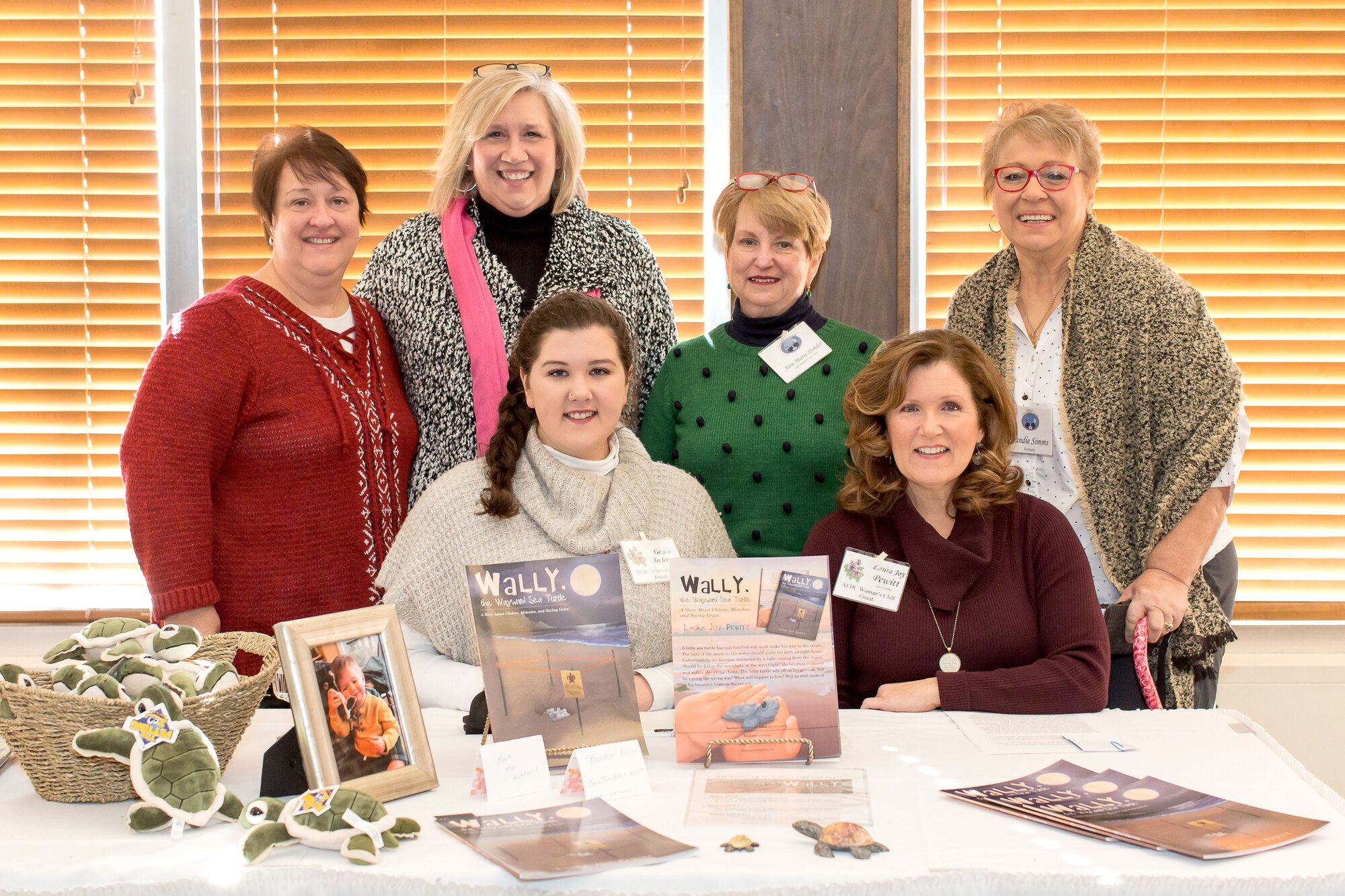The AEDC Woman’s Club members look at products displayed by AEDCWC meeting presenter Laura Joy Pewitt at a Jan. 4 meeting. Pewitt is the author of the children’s book “Wally, the Sea Turtle: A story about Choices, Mistakes, and Saving Grace.” She shared with AEDCWC meeting participants her journey to becoming a published author. Pictured on the back row, from left is Anne Wonder, Kate Canady, Grace Anderson, Anne-Marie Pender; front row, Pewitt, and Sandie Simms. (Courtesy photo)