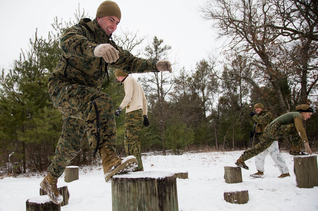 Marines climb up logs of different sizes.