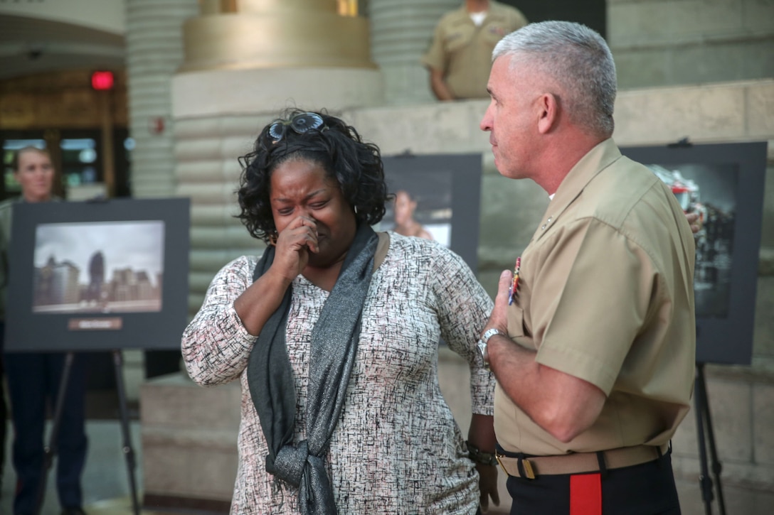 A Marine Corps general talks to a woman who is crying.