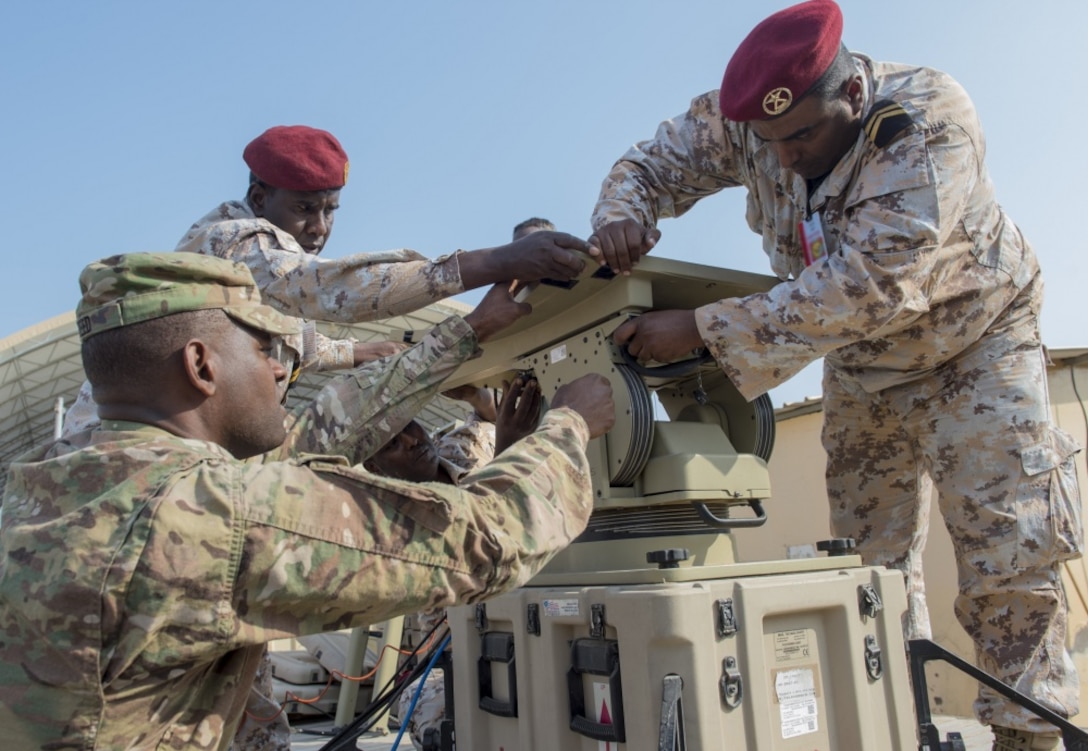 Army Spc. William Reed, a multisystem transmission operator and maintainer assigned to Combined Joint Task Force-Horn of Africa’s communications directorate, watches as a Djiboutian service member sets up an antenna during a military-to-military exchange course at Camp Lemonnier, Djibouti.