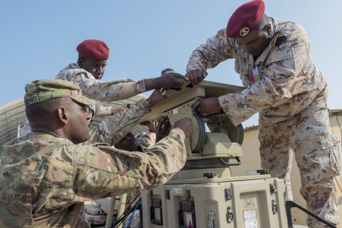 Army Spc. William Reed, a multisystem transmission operator and maintainer assigned to Combined Joint Task Force-Horn of Africa’s communications directorate, watches as a Djiboutian service member sets up an antenna during a military-to-military exchange course at Camp Lemonnier, Djibouti.