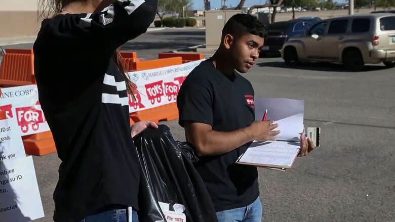 U.S. Marines assigned to Marine Fighter Training Squadron (VMFT) 401 offer helping hands to the Toys for Tots event at the Arizona Western College Conference Center, Dec. 18, 2017. Toys for Tots was founded by U.S. Marine Corps Reservist Maj. William L. Hendricks in 1947 and in 1991, the Secretary of Defense, Dick Cheney, made Toys for Tots an official mission of the Marine Corps Reserves. (U.S. Marine Corps video screenshot by Lance Cpl. Eric Q. Shannon)