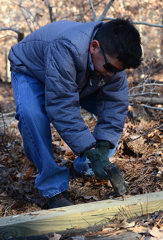 Michael DeLeon, age 11, Fort Eustis Boys Scouts Troop 45 member and son of U.S. Army Sgt. 1st Class Michael DeLeon, 1st Battalion, 210th Aviation Regiment, 128th Aviation Brigade instructor writer, installs posts around a cemetery plot at Joint Base Langley-Eustis, Va., Jan. 20, 2018.