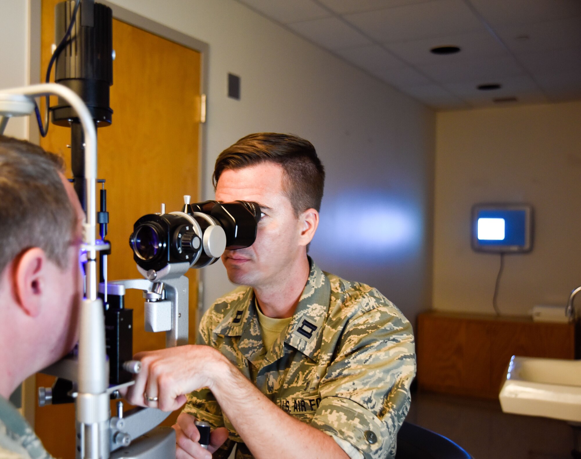Capt. Brian Gill, 114th Medical Group optometrist, performs an eye exam on a patient at Schofield Health, Wahiawa, Hawaii Clinic, Jan. 17, 2017. Approximately 15 Airmen from the 114th Medical Group worked at Tripler Army Medical Center and Schofield Barracks Health Clinic. (U.S. Air National Guard photo by Staff Sgt. Duane Duimstra)