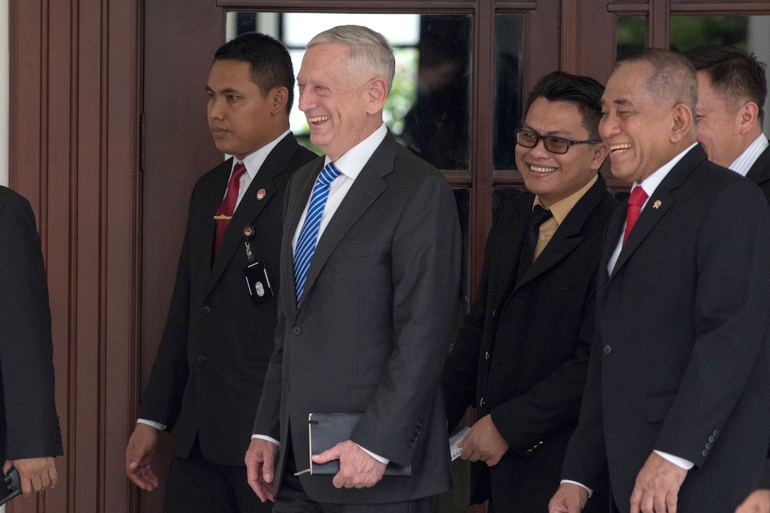 Defense Secretary James N. Mattis walks with a group of people.