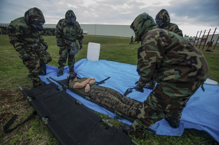 Marines with Combat Logistics Regiment 35 prepare to lift a simulated casualty, Lance Cpl. Isaac Jordan a machinist with Maintenance Battalion, CLR 35, for transport to a decontaminated zone during decontamination training on Camp Kinser, Okinawa Jan. 23, 2018. This training is held by CLR 35 to reinforce how to effectively help the wounded in case of a chemical, biological, radioactive or nuclear attack. (Marine Corps photo taken by Pfc. Jamin M. Powell)