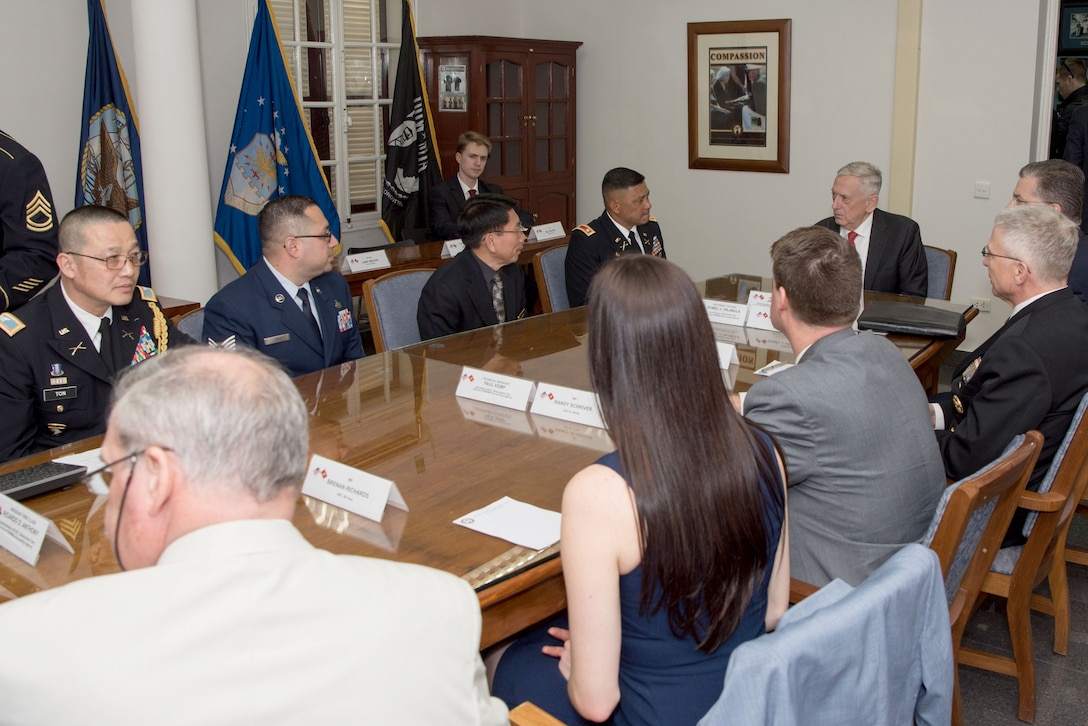 Defense Secretary James N. Mattis sits at the head of a table.