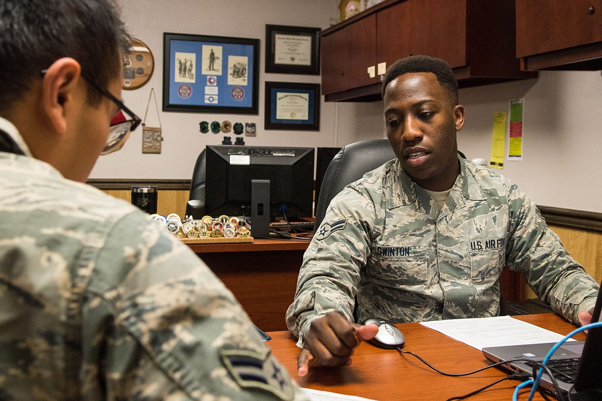 irman 1st Class Vaughn Swinton (right), 4th Comptroller Squadron financial operations technician, assists Airman 1st Class Tin Diep, 4th Aircraft Maintenance Squadron avionics technician, with his in processing, Jan. 17, 2018, at Seymour Johnson Air Force Base, North Carolina.