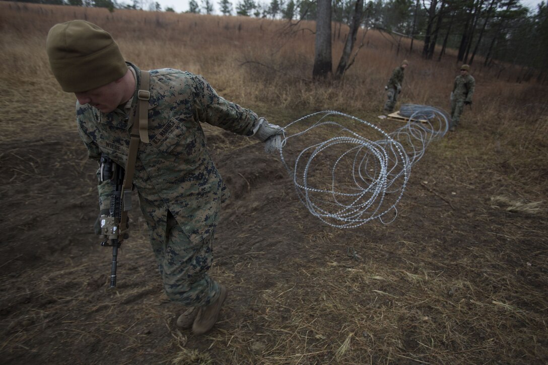 Cpl. Richard Wiebe, a Marine with 2nd Battalion, 8th Marine Regiment, drags a section of concertina wire to create an obstacle at a platoon live-fire range during a pre-deployment training exercise at Fort A.P. Hill, Va., Dec. 7, 2017. The Marines are conducting the training to maintain proficiency at the squad, platoon, company, and battalion-level of warfighting in preparation for an upcoming deployment to Japan. The Marines patrolled, detonated Bangalore torpedoes to breach obstacles, threw M67 fragmentation grenades to clear trenches, and conducted live-fire movements to take an objective. (U.S. Marine Corps photo by Lance Cpl. Ashley McLaughlin)