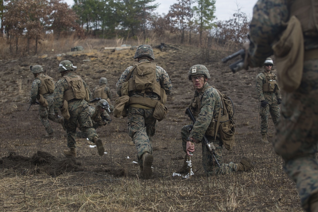 Cpl. Richard Wiebe, a combat engineer with 2nd Battalion, 8th Marine Regiment, guides Marines through a cleared obstacle at a platoon live-fire range during a deployment for training exercise at Fort A.P. Hill, Va., Dec. 7, 2017. The Marines are conducting the training to maintain proficiency at the squad, platoon, company, and battalion-level of warfighting in preparation for an upcoming deployment to Japan. The Marines patrolled, detonated Bangalore torpedoes to breach obstacles, threw M67 fragmentation grenades to clear trenches, and conducted live-fire movements to take an objective. (U.S. Marine Corps photo by Lance Cpl. Ashley McLaughlin)