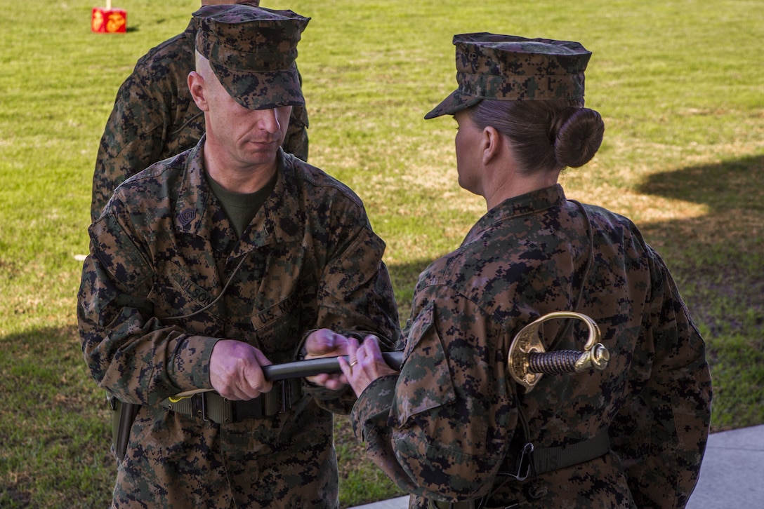 Sgt. Maj. David A. Wilson, off-going sergeant major for I Marine Expeditionary Force Information Group, passes the non-commissioned officer’s sword to Col. Dawn R. Alonso, commanding officer, I MIG, during a relief and appointment ceremony at the 11 area parade deck aboard Camp Pendleton, California, Jan. 18, 2018.